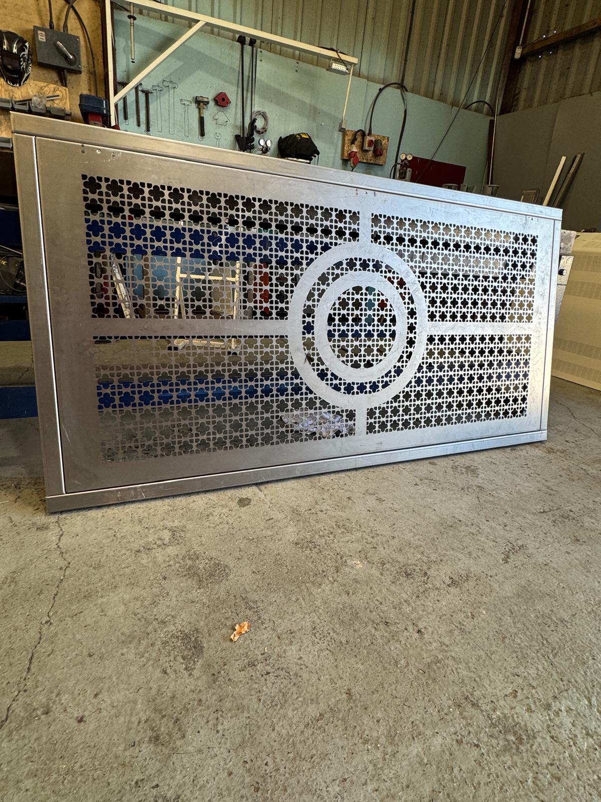 Unfinished bespoke radiator front panel in the workshop, showing circular detailing and decorative perforations