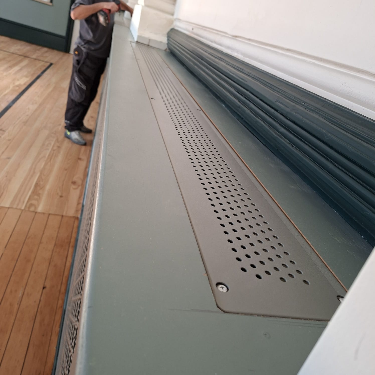 Perforated top ventilation panel recessed into the timber radiator casing at Sandown Town Hall